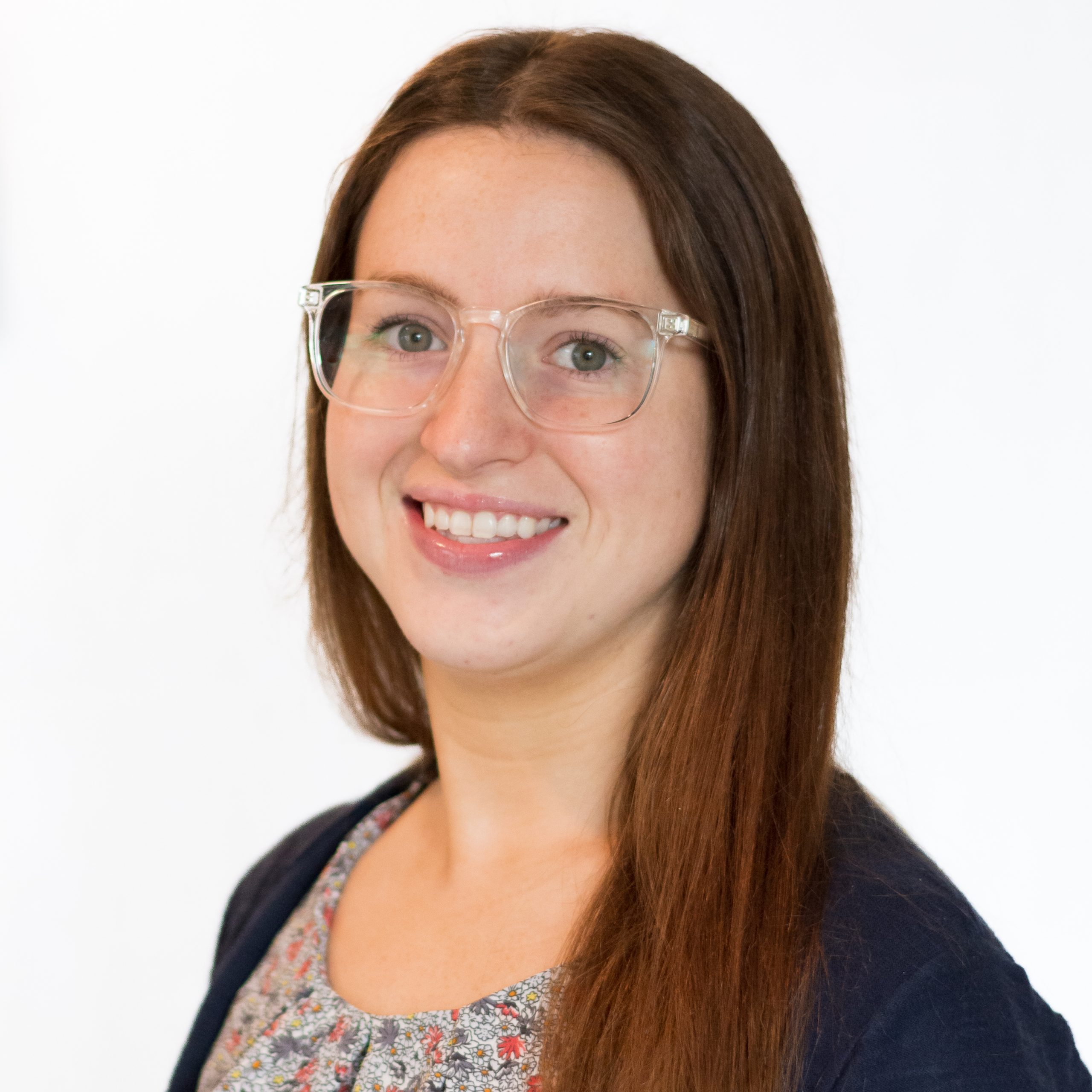 Headshot Brielle Psychotherapy Neurofeedback Intern brown hair, blue eyes, glasses, flower top smiling